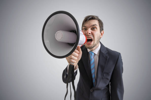 istock Young man is announcing a message and shouting to megaphone. 677522502