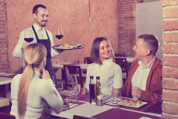 istock Male waiter bringing order to visitors 677534094