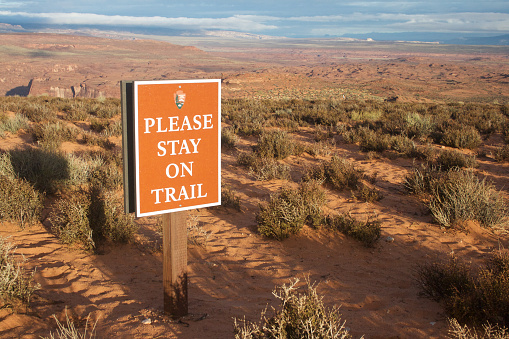 Page, AZ, USA – October 25, 2016: A sign saying “please stay on trail” at Horseshoe Bend parking lot asking tourists and visitors to stay on trail on their way to Horseshoe Bend viewpoint