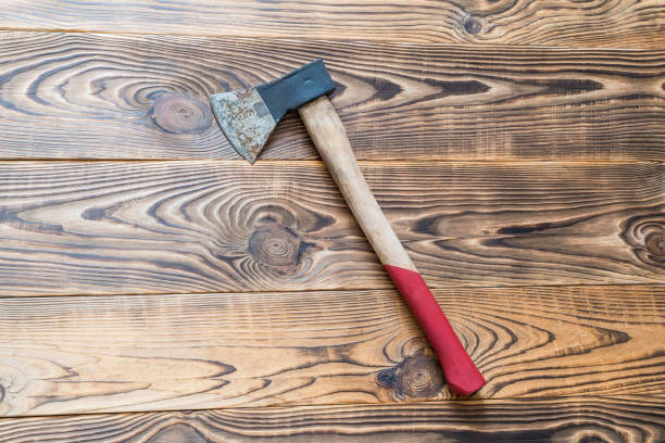 istock Big rusty ax on aged wooden background 677567472