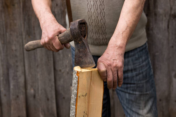 istock Worker, an elderly man with an old axe chops firewood. Forced to work in retirement . Employee . 677595046