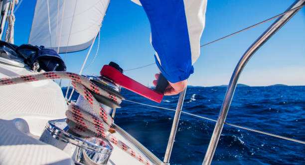 hand wickeln seil mit seilwinde auf segelboot - cable winch sailing yacht sport stock-fotos und bilder