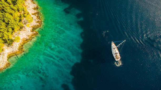 istock Tourists swimming by the sailboat 677595678