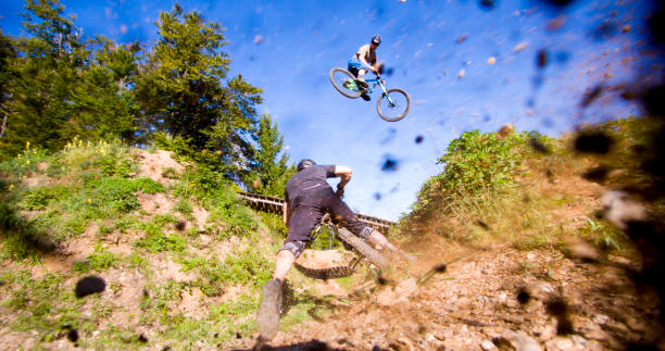 istock Mountain bikers performing stunts against sky 677595900