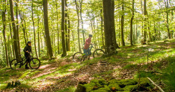 istock Mountain bikers with bicycles walking in forest 677595924