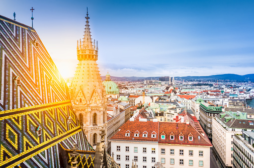 Aerial view over the historical rooftops of Vienna from the north tower of famous St. Stephen's Cathedral in beautiful golden evening light at sunset in summer, central Vienna, Austria
