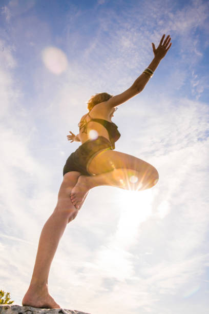 istock Woman doing yoga under the sun 677600138