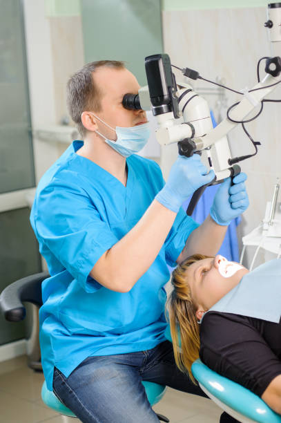 istock Male dentist working with microscope at modern dentist clinic 677607110
