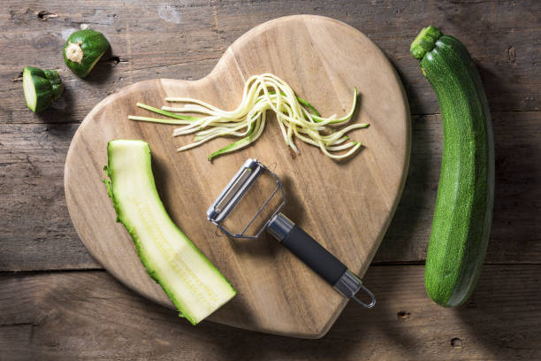 istock Strands of julienned courgette on a heart shaped chopping board 677621050