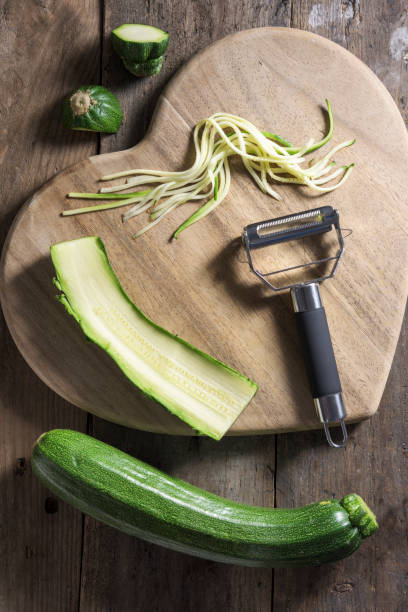 istock Strands of julienned courgette on a heart shaped chopping board 677621766