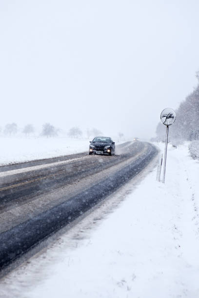 istock Heavy snowfall on German country road 677639026