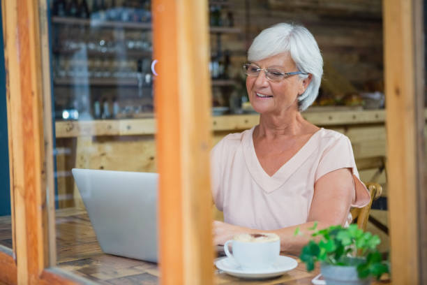 istock Senior woman talking on mobile phone while having coffee 677662324