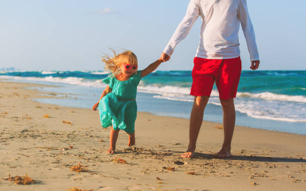 istock father and little daughter play at beach 677662624