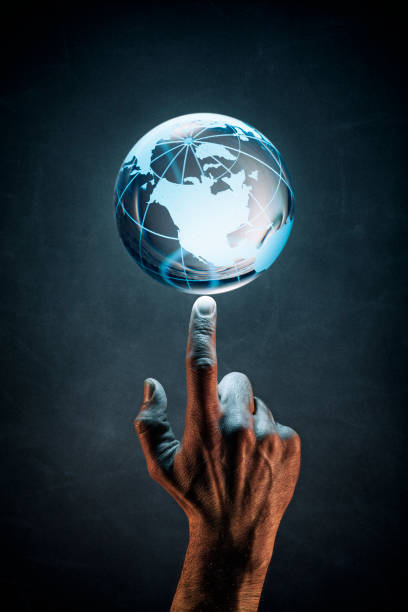 Photography of a male handpointing at a blue glowing glas globe.