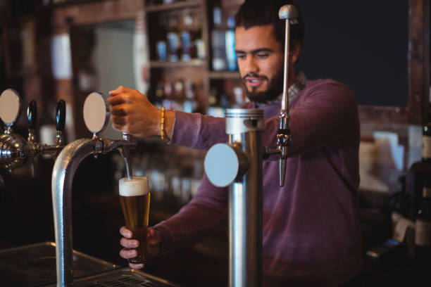 istock Bar tender filling beer from bar pump 677671380