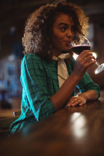 istock Woman having wine at bar counter 677676220