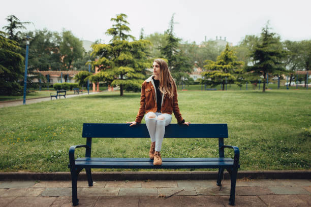 istock Young woman sitting on a bench 677702028