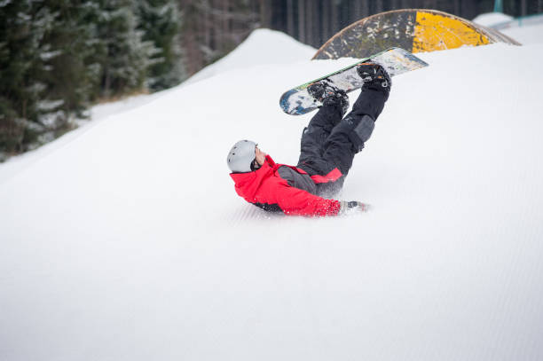 istock Snowboarder falls on the slopes during the jumping 677749896