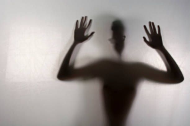 istock Young boy standing behind frosted glass.image creates feeling of depression,Behind a screen,Blurry shadow 677751452