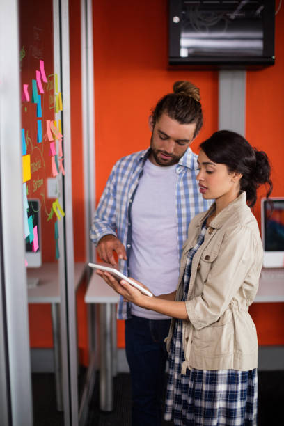 istock Male and female executives discussing over digital tablet 677764454