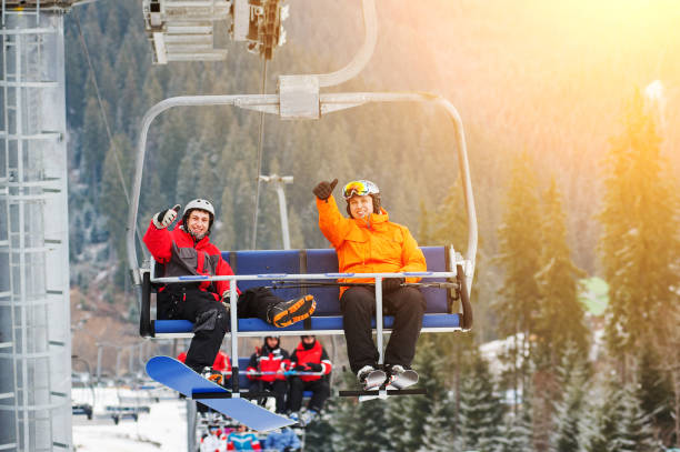 istock Skier and snowboarder riding up on ski lift 677776394