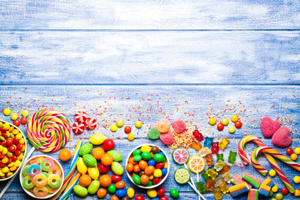 kolorowe cukierki na niebieskim stole - stick of hard candy candy vibrant color multi colored zdjęcia i obrazy z banku zdjęć