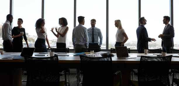 Businesspeople Stand And Chat Before Meeting In Boardroom Businesspeople Stand And Chat Before Meeting In Boardroom wide screen stock pictures, royalty-free photos & images