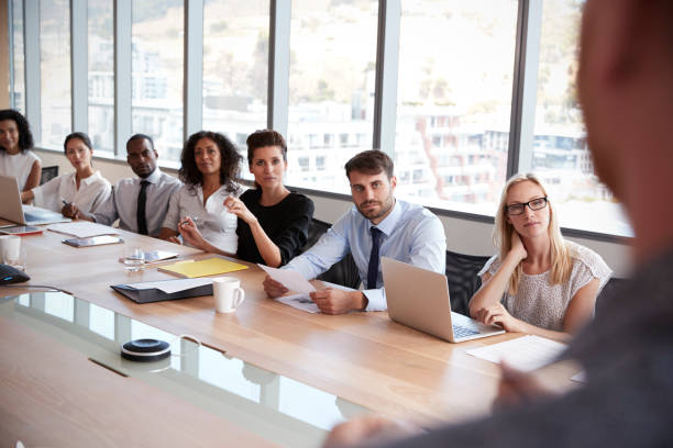 istock Businessman Stands To Address Meeting Around Board Table 677809778