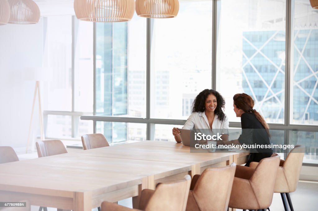 회의실 회의에서 노트북을 사용하는 두 명의 비즈니스 우먼 - 로열티 프리 모임 스톡 사진