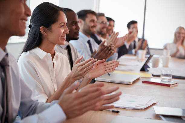 istock Businesspeople Around Boardroom Table Applaud Presentation 677809892
