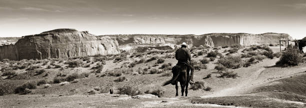 western cowboy nativo americano a cavallo al monument valley tribal park - monument valley usa panoramic foto e immagini stock