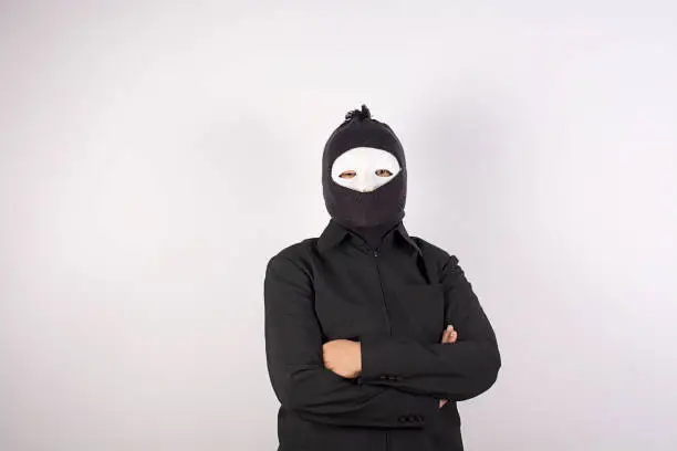 Photo of Portrait of woman in balaclava standing with arms crossed.
