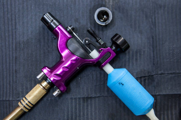 istock Tattoo artist table with ink small cup and purple gun ink machine 677873178