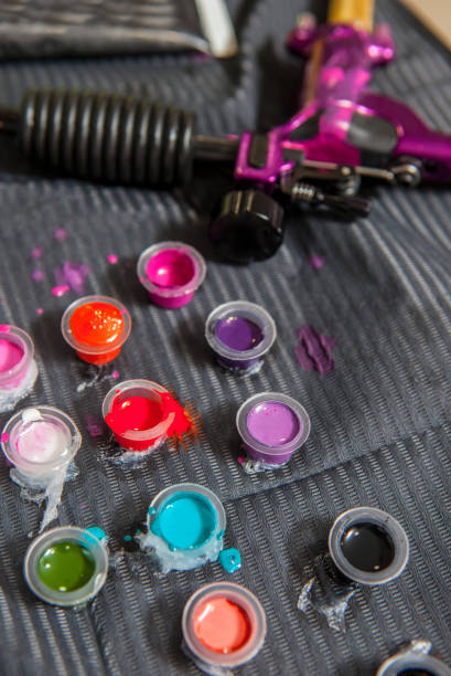 istock Tattoo artist table with several small cups and gun ink machine 677873180