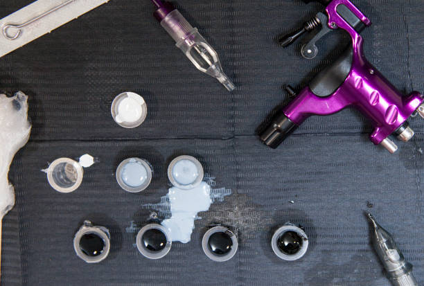 istock Tattoo artist table with several ink small cups and gun ink machine 677873228