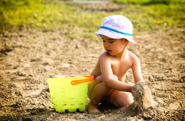 istock Cute little girl playing with sand 677874394