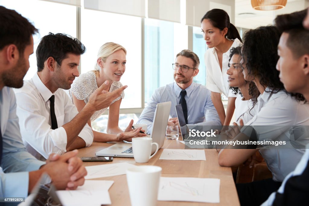 Group Of Businesspeople Meeting Around Table In Office Business Meeting Stock Photo