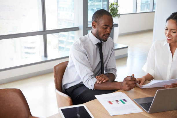istock Businesspeople Working On Laptop In Boardroom Together 677893488