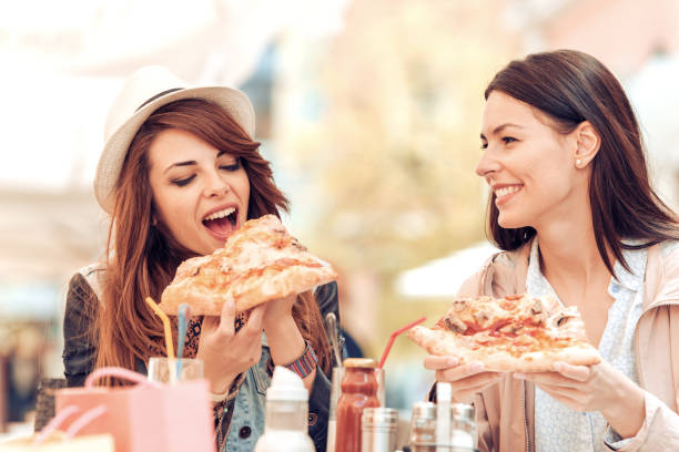istock Two cheerful  girls eating pizza 677906994