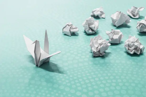 Success concept, A origami paper bird and crumpled paper balls