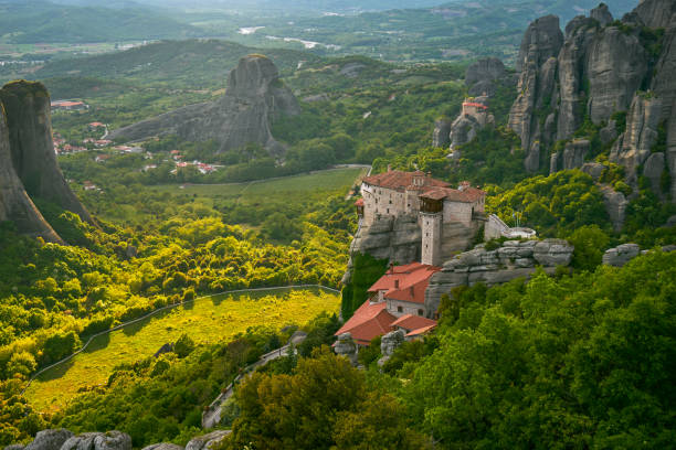 meteora, grecia. il monastero di holly di rousanou sullo sfondo. - meteora monk monastery greece foto e immagini stock