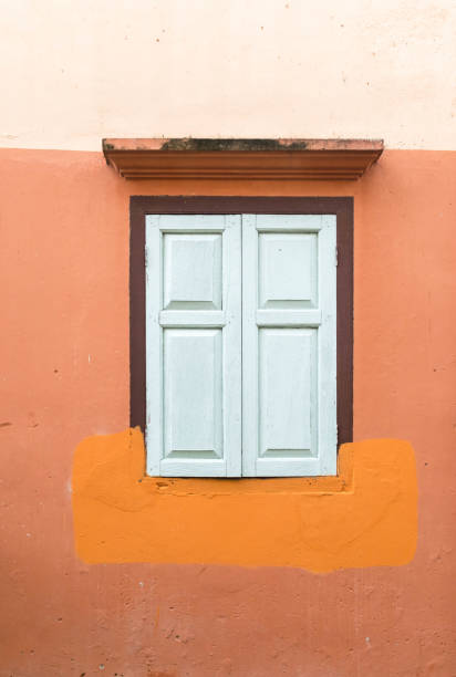 istock Old white wood window on the orange wall. 677916570