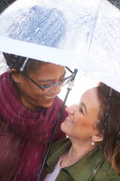 istock female couple out in the rain 677918142