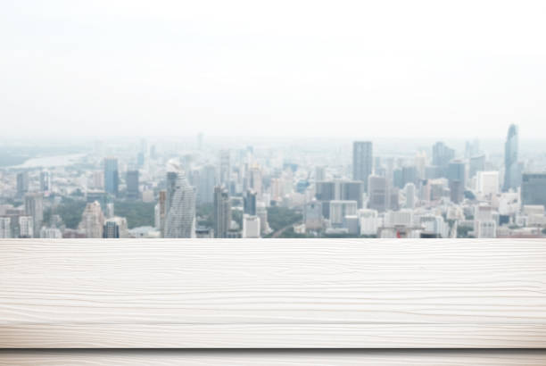 istock Empty white wood table over blur city scrape background, template, product display montage, mock up 677923602