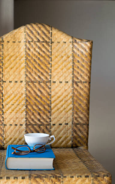 istock Book, cup and eyeglasses on a chair. 677929432