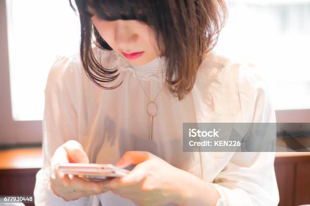 Photo libre de droit de スマホを操作する可愛い 女性 banque d'images et plus d'images libres de droit de Femmes - Femmes, Téléphone mobile intelligent, Seulement des femmes