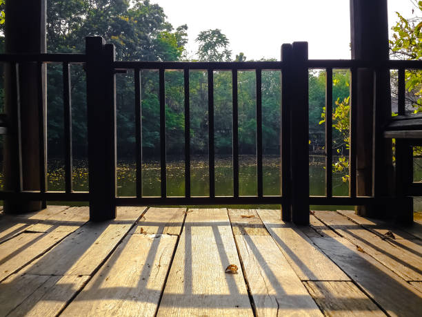 istock railing shadow casting on vintage wooden balcony floor 677931430