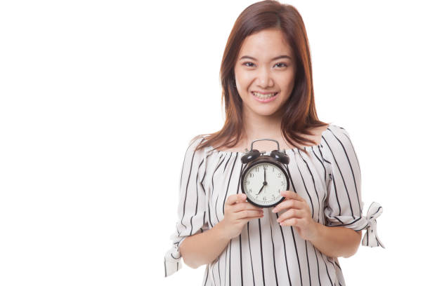 istock Young Asian woman smile with a clock. 677942320