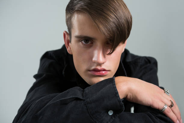 istock Androgynous man in black shirt posing against grey background 677944864