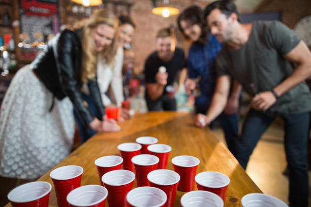 istock Friends enjoying beer pong game in bar 677944882